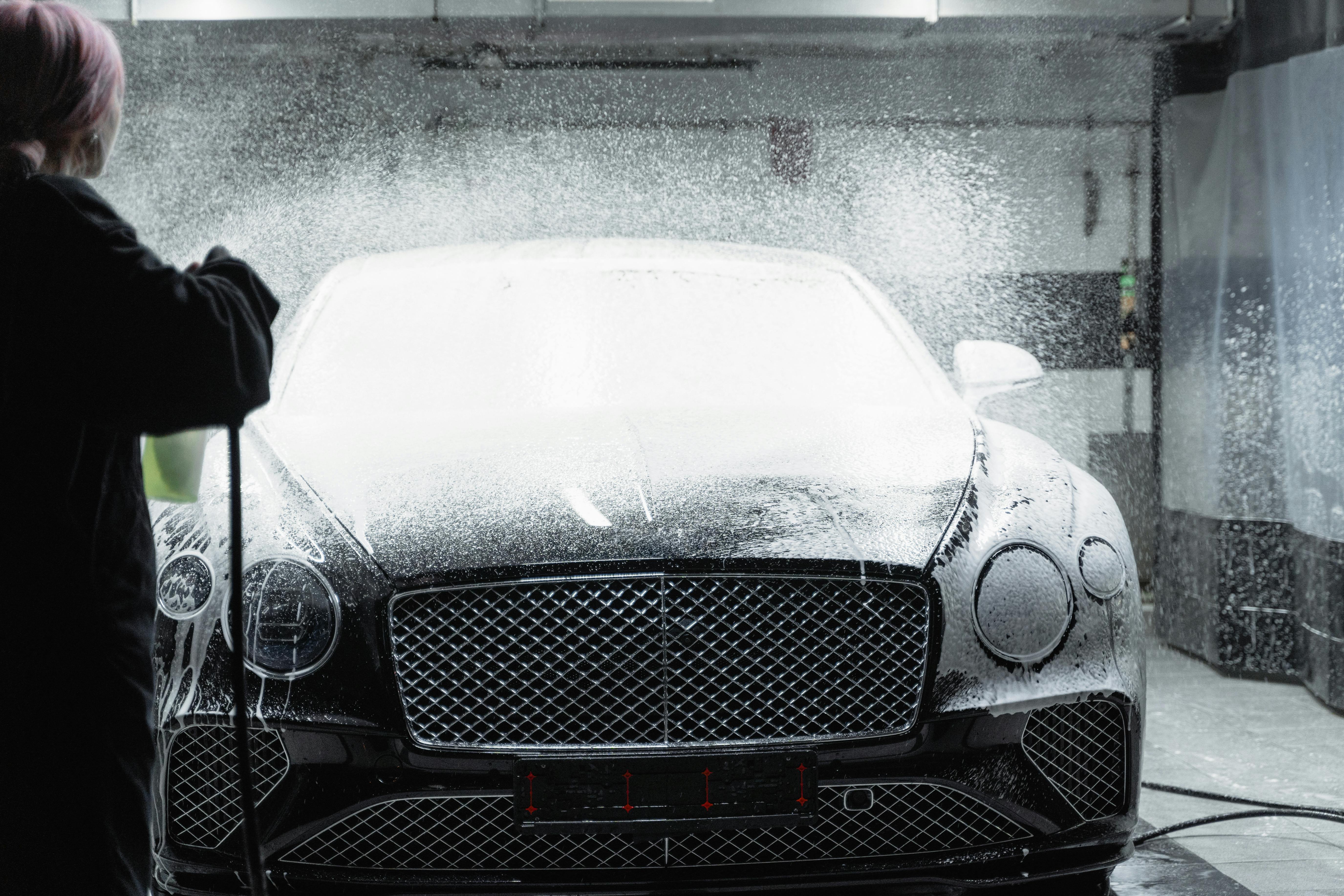 Bentley Continental being pressure washed with dramatic water spray