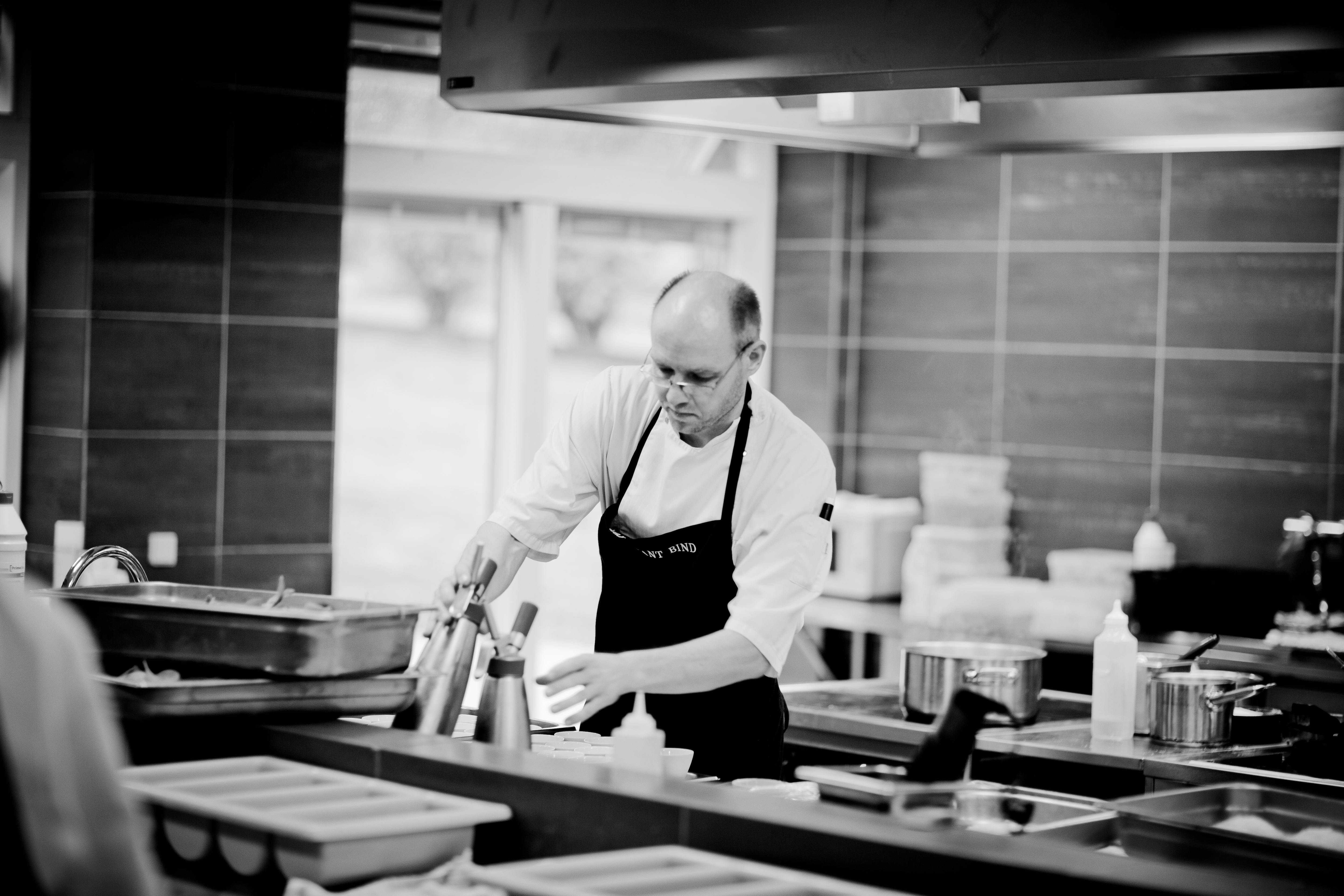 Black and white portrait of chef at work in professional kitchen