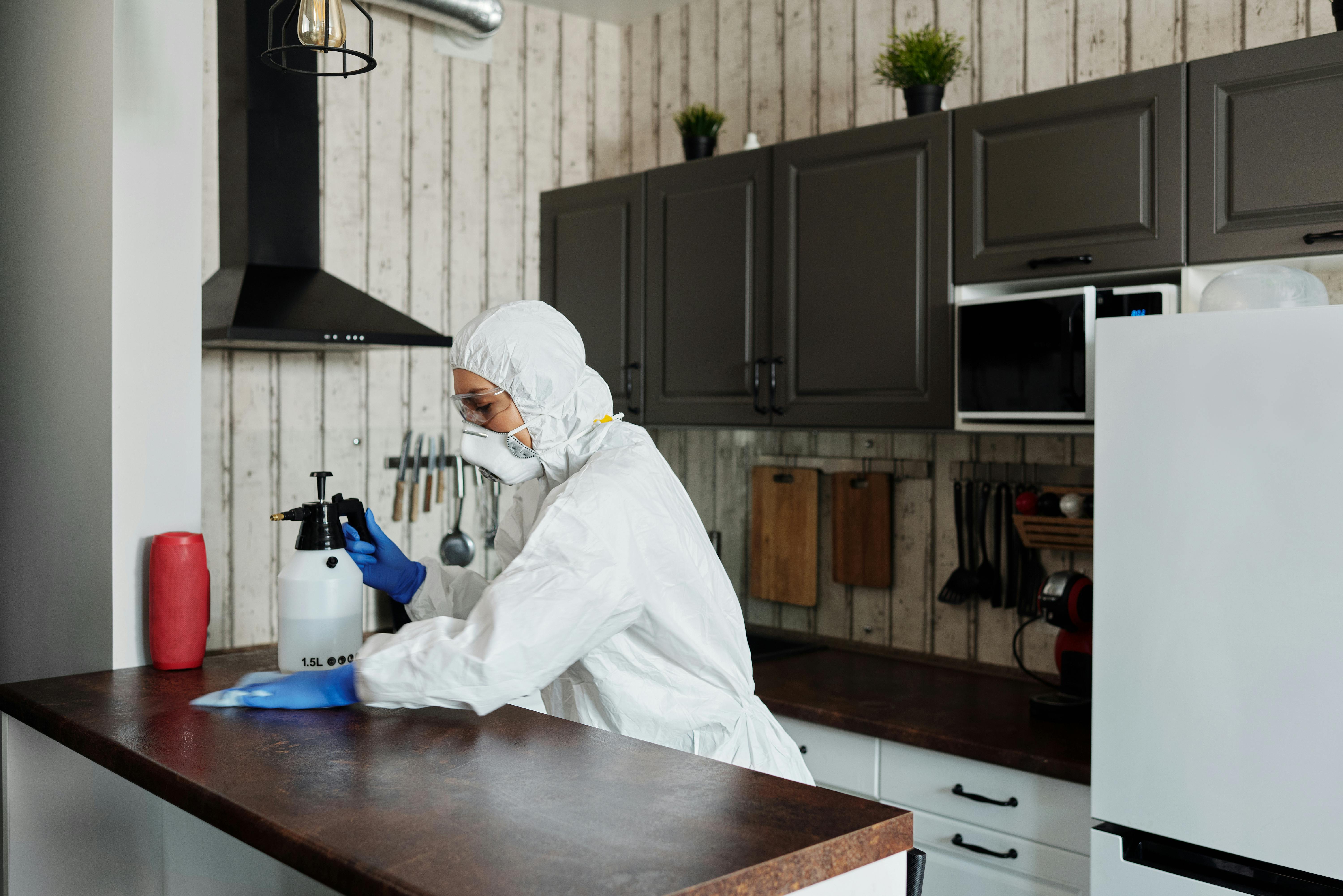 Professional cleaner wiping down a kitchen worktop