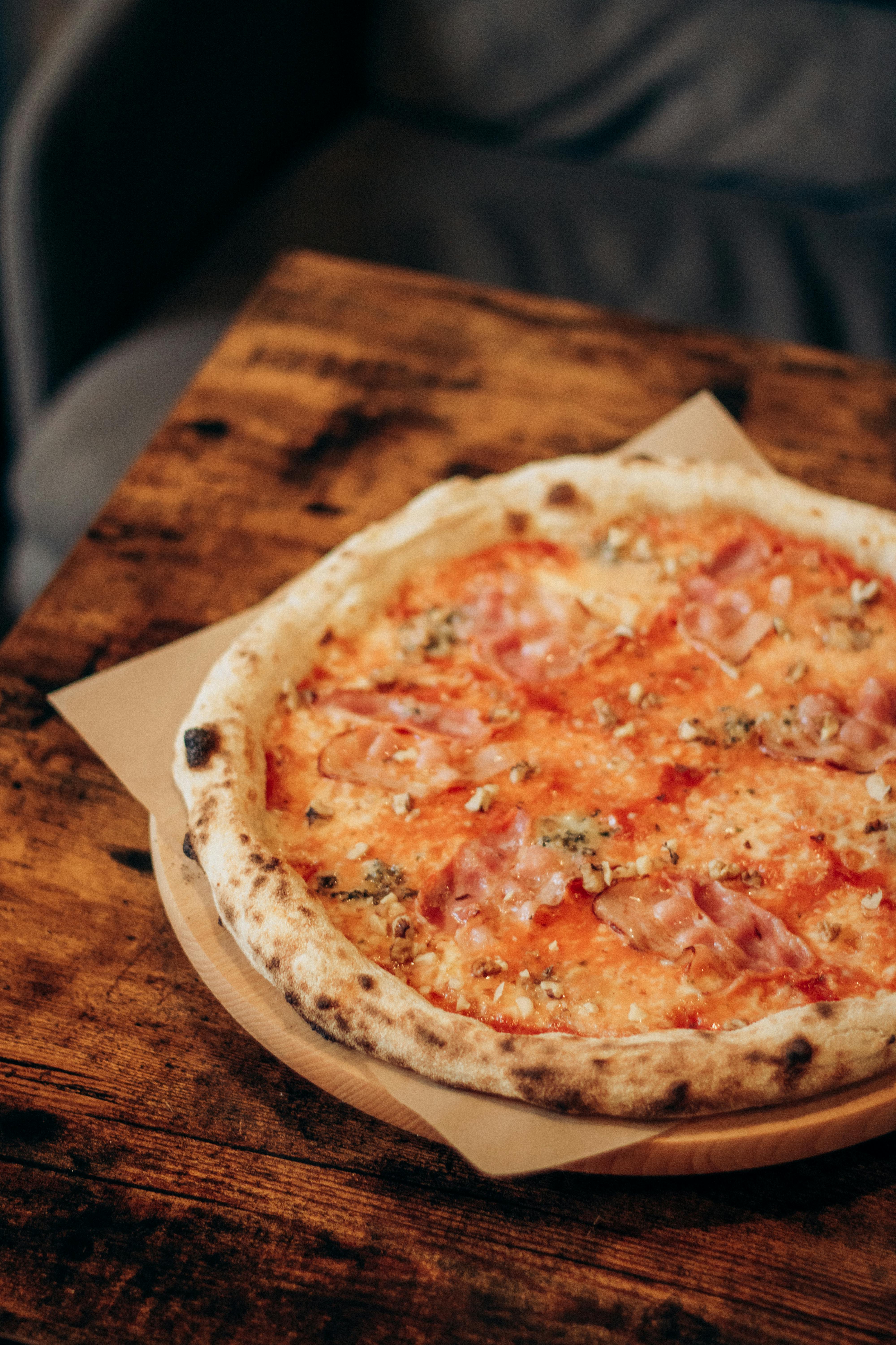 Artisan pizza on rustic wooden board, moody intimate lighting