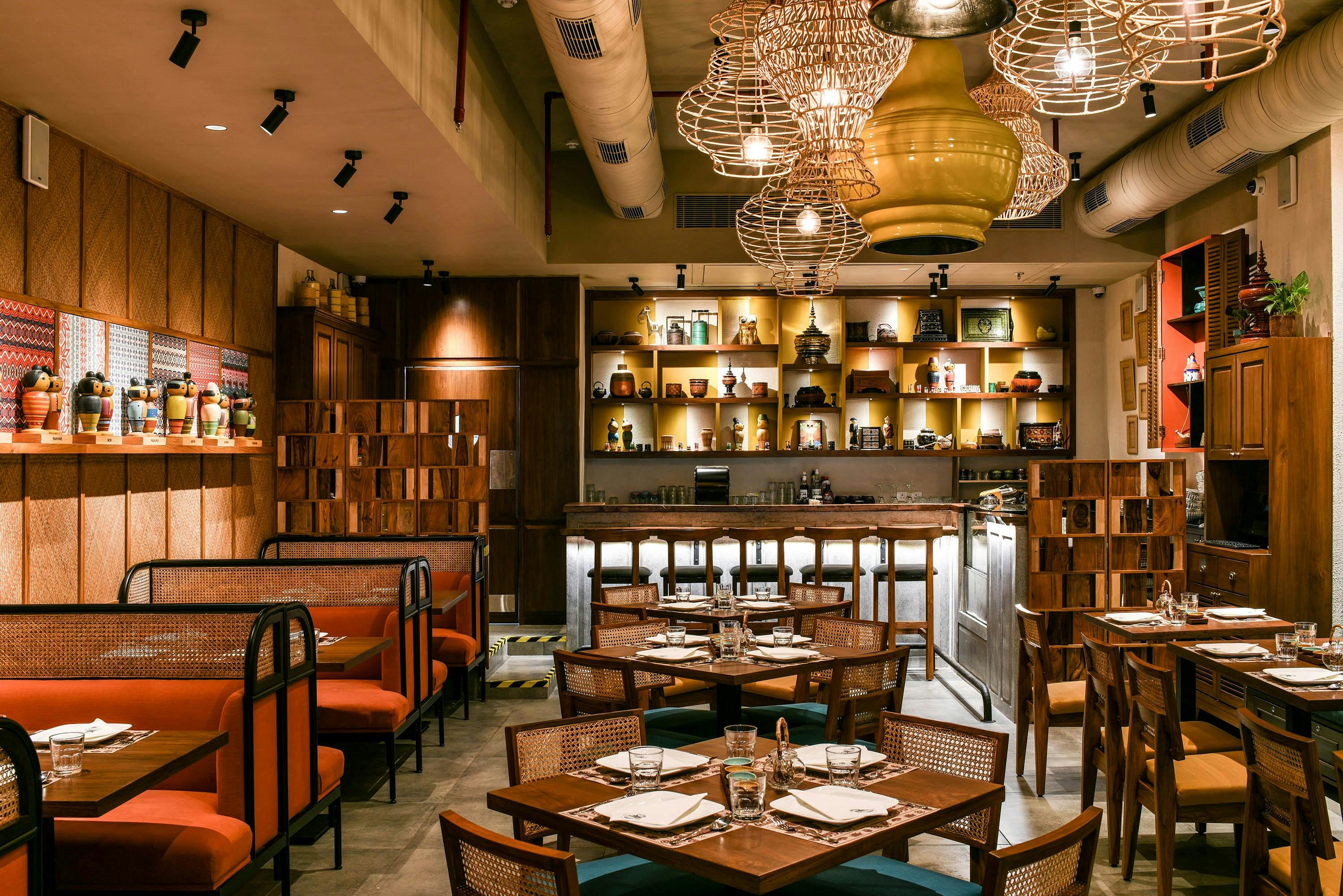 Full restaurant interior with statement pendant lights, bar area, warm atmosphere